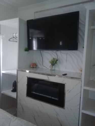 sala de estar con chimenea y TV de pantalla plana en 7hills comfort suites, en Cooperʼs Town