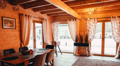 uma sala de jantar com uma mesa e uma grande janela em Gwiazda Północy Gołdap Dom VIP na Wynajem em Gołdap