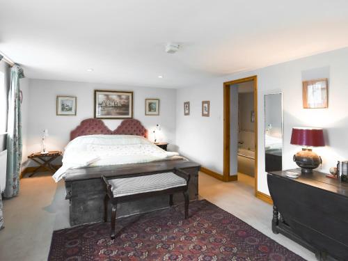 a bedroom with a bed and a dresser and a table at The Cow Shed in Quatford