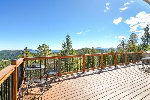 a wooden deck with chairs and a table on it at The Tree House in Evergreen