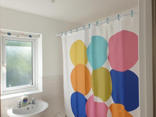 uma casa de banho com uma cortina de chuveiro, um WC e um lavatório. em Perfect Stay Manchester em Wythenshawe