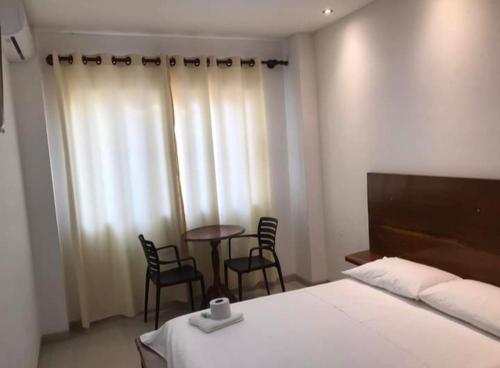 a bedroom with a bed and chairs and a table at Hadasa in Santa Cruz de la Sierra