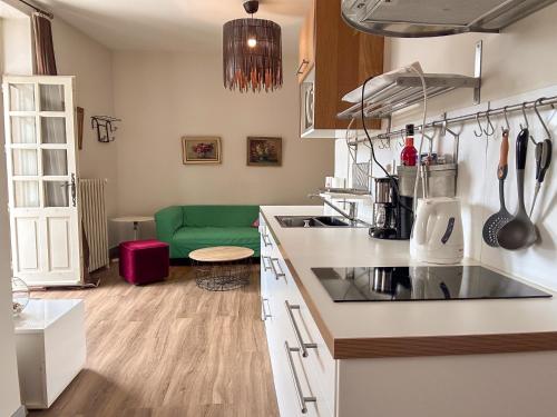een keuken met een groene bank in een kamer bij La Terrasse in Saint-Paul-Trois-Châteaux