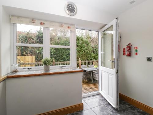 a kitchen with a counter and a window at About Time Cottage in Lydney