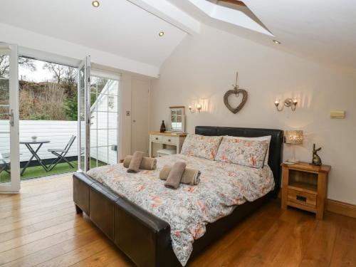 una camera da letto con un grande letto con cuscini sopra di About Time Cottage a Lydney
