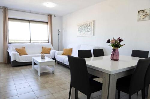 ein Wohnzimmer mit einem Tisch und einem Sofa in der Unterkunft Playa Mucha Vista apto, Parking, Piscina, AC in El Campello