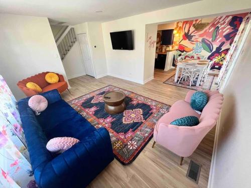 a living room with a blue couch and two chairs at Luv Happii House in Country Club Hills