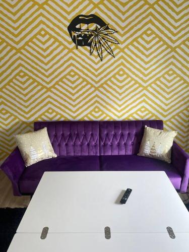 a purple couch with two white tables in a room at Luv Happii House in Country Club Hills