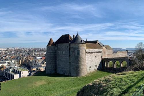 um castelo numa colina com uma cidade ao fundo em Rez-de-chaussée de plain-pied avec parking privé au centre ville em Dieppe