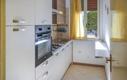 a kitchen with white cabinets and a stove top oven at Nice Apartment In Marzamemi in Marzamemi