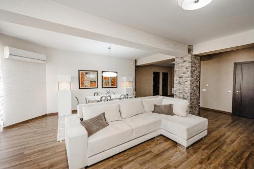 a living room with a white couch and a table at Spacious apartment close to Valea Trandafirelor park! in Chişinău