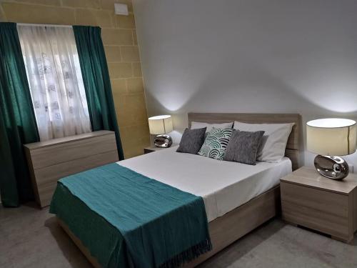 1 dormitorio con 1 cama con 2 lámparas y una ventana en Apartment close to the sea, en Marsaskala