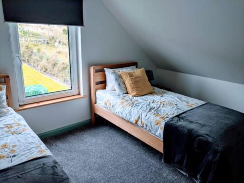 1 dormitorio con cama y ventana en An Teach Beag Glencolmcille, little home from home, en Glencolumbkille