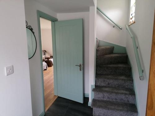 a hallway with a door leading to a stairway at An Teach Beag Glencolmcille, little home from home in Glencolumbkille
