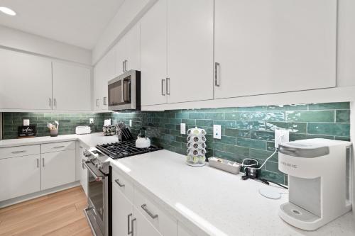 uma cozinha com armários brancos e azulejos verdes em Gated PGA West 2023 New Build - EV Friendly em La Quinta