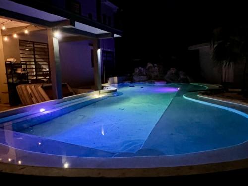a swimming pool at night with lights on it at Hokhmah Heart Hotel in Puerto Morelos