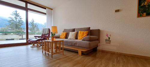 a living room with a couch and a large window at Direkter Seezugang am Ossiacher See, Radfahren, Wandern & Erlebniscard in Villach