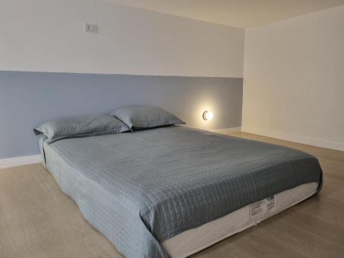 um quarto com uma cama grande num quarto branco em LOFT MUNDI - Conforto no Centro com Ar Condicionado em Águas de Lindoia