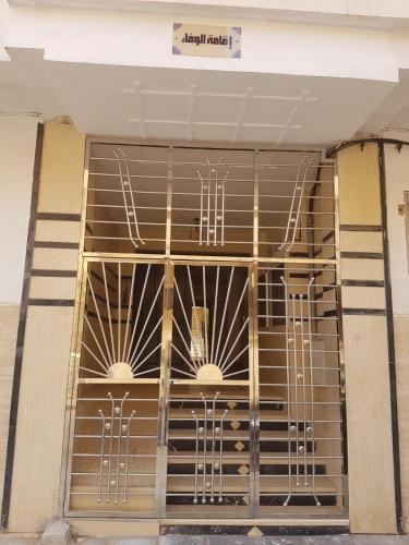 een voordeur van een gebouw met metalen staven bij Appartement spacieux meublé in Oujda