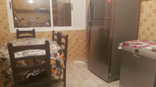 een keuken met 2 stoelen en een koelkast bij Appartement spacieux meublé in Oujda