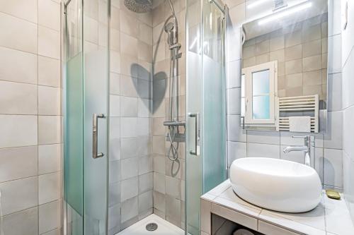 une salle de bain avec un lavabo et une douche en verre dans l'établissement Appart Tour Eiffel / Champs de Mars, à Paris