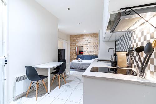 une cuisine avec un évier et une table avec des chaises dans l'établissement Appart Tour Eiffel / Champs de Mars, à Paris