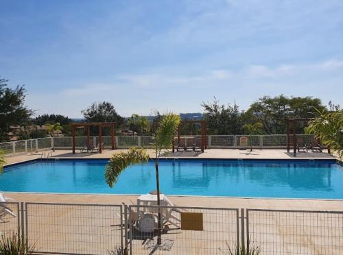 a large swimming pool with a fence around it at Quarto em casa com lazer completo in Indaiatuba