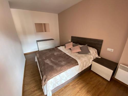 1 dormitorio con 1 cama grande con almohadas rosas en Apartamento Gold Cadí, en Guardiola de Berguedà
