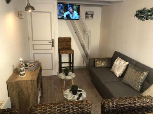 een woonkamer met een bank en een trap bij petit maison Indépendant ile oleron sans ext in Grand-Village-Plage