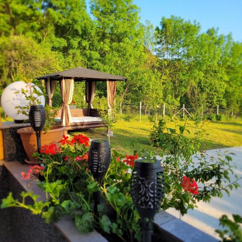 a garden with a gazebo and some flowers at Hanul Doctorului Badeni-Runcu Vila 2 in Fieni