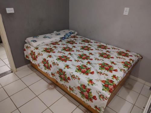 ein Bett mit einer Decke mit Blumen drauf in der Unterkunft APTO mobiliado Candeias, JBO/PE in Recife