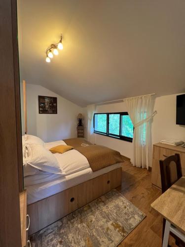 a bedroom with a large bed and a window at Hanul Doctorului Badeni-Runcu Vila 2 in Fieni