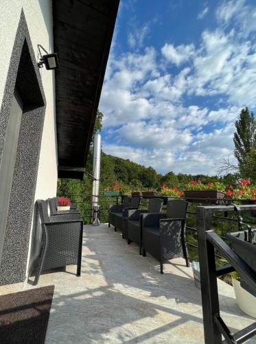 a row of chairs sitting on a patio at Hanul Doctorului Badeni-Runcu Vila 2 in Fieni