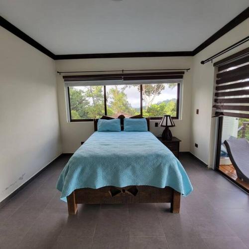een slaapkamer met een bed en een groot raam bij Villa Hermosa in Jarabacoa
