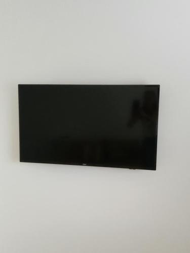 a flat screen tv sitting on a white wall at Chalet con pileta y quincho, hermoso jardín in Tandil