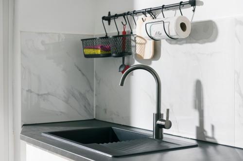 a kitchen counter with a sink and a basket on the wall at 44 Apartments - Modern, Gemütlich, WLAN, Balkon, Stellplatz in Wuppertal