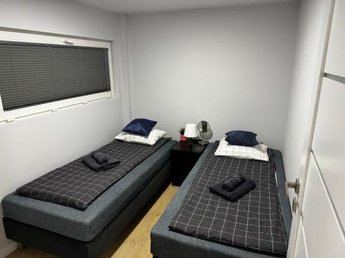 two twin beds in a room with a window at Klimatyzowane Apartamenty przy Targach Kielce, Trade Fair in Kielce