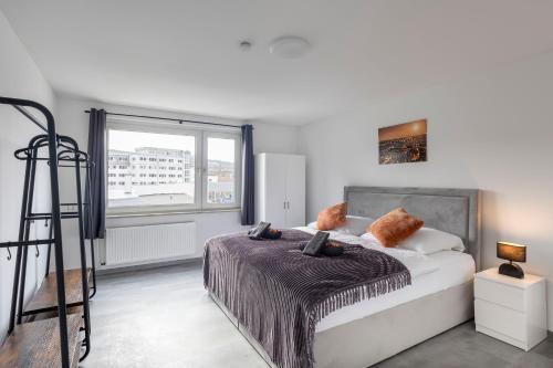 um quarto com uma cama e uma grande janela em 44 Apartments - Modern, Gemütlich, WLAN, Balkon, Stellplatz em Wuppertal