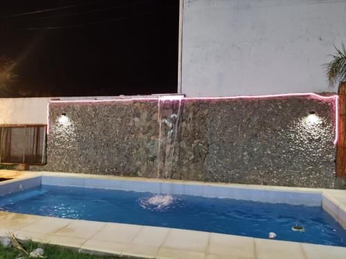 una piscina con cascada en un patio trasero por la noche en La Posada del Norte en La Rioja