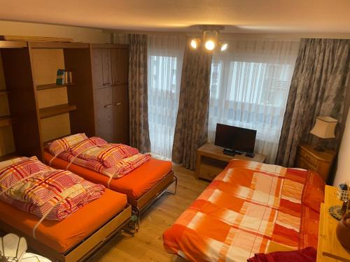 a hotel room with two beds and a television at Montanji 11 in Leukerbad