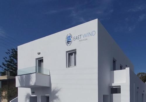a white building with the words east winds on it at East Wind Perissa in Perissa