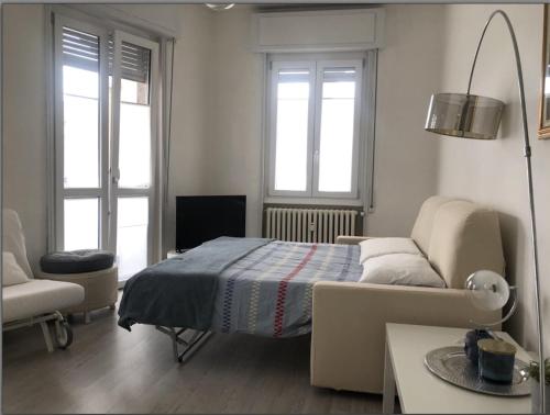 - une chambre avec un lit, un canapé et deux fenêtres dans l'établissement Holly's House apartment, à Alzano Lombardo