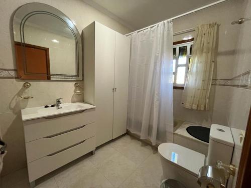 een badkamer met een wastafel, een toilet en een spiegel bij Casa Rural Los Tilos Betancor in Moya