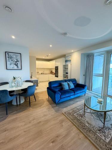a living room with a blue couch and a table at Elegant 2 Bedroom Apartment in Grand Canal in Dublin