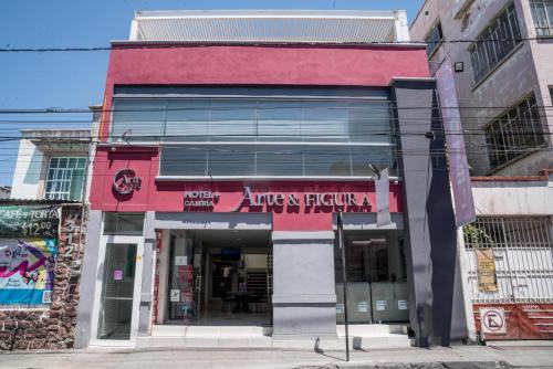 a building with a red sign on the front of it at Hotel del Arte y Figura in León
