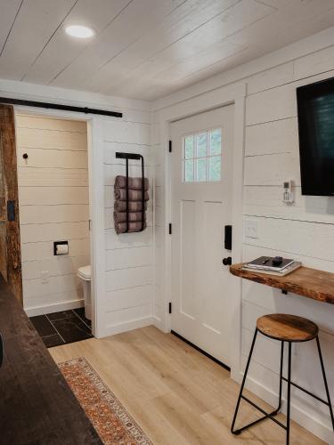 Cette chambre dispose de toilettes et d'une porte avec un tabouret. dans l'établissement Shipping Container Home near Fall Creek Falls State Park, à Dunlap