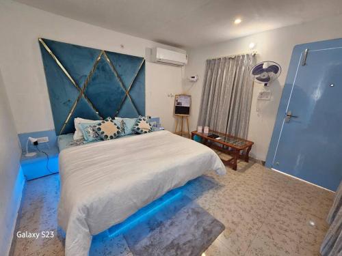 a bedroom with a large bed with a blue headboard at MistyBlue - The Penthouse Best Sunrise View Room in Orchha