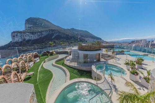 a view of a resort with a pool and a mountain at Urban Oasis at Luxurious Ocean Village in Gibraltar