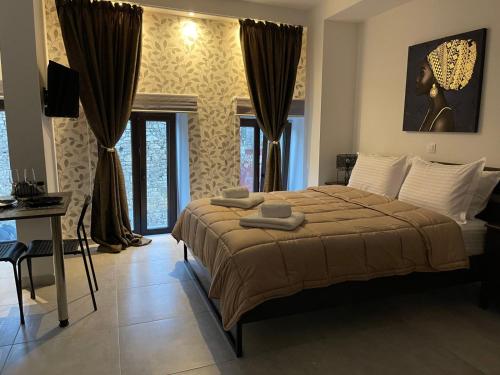 a bedroom with a bed and a desk and windows at Boutique at Historic Centrum-with free parking in Ioannina