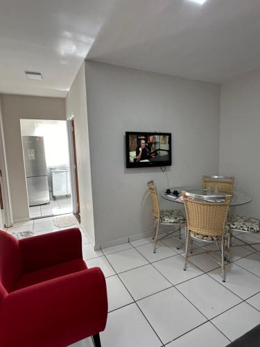 a living room with a red couch and a table at Apartamento em Várzea Grande MT in Várzea Grande